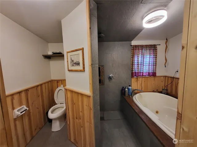 a bathroom with a granite countertop bathtub shower sink and toilet