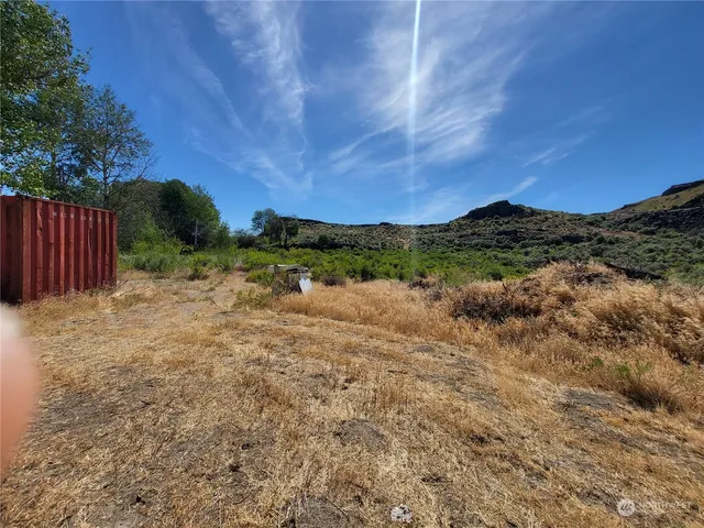 a view of a yard with wooden fence