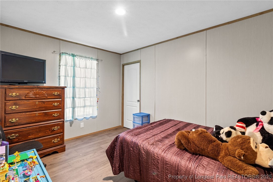 7096 Monarch Drive Linden, NC 28356 - Photo 29 of 31 a bedroom with a bed and a flat tv screen on dresser