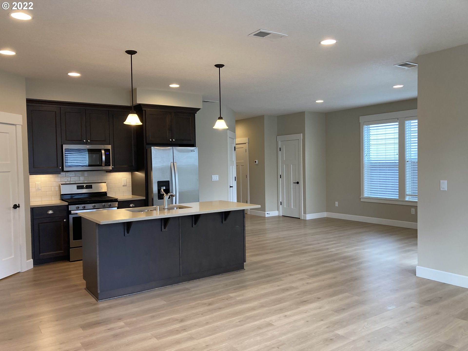 7415 South 13th Street Ridgefield, WA 98642 - Photo 14 of 28 a kitchen with stainless steel appliances granite countertop a sink a stove and a wooden floors
