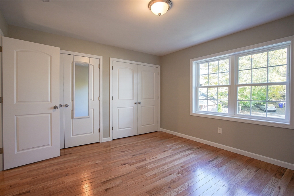 18-20 Healey Street, Unit 20 Springfield, MA 01151 - Photo 13 of 14 a view of an empty room with wooden floor and a window