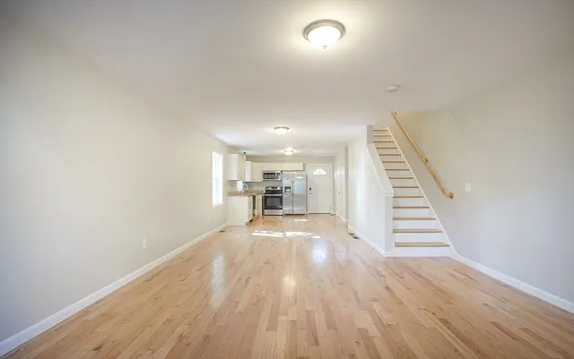 a view of a hallway with wooden floor and staircase
