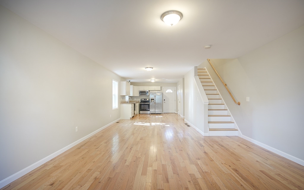 18-20 Healey Street, Unit 20 Springfield, MA 01151 - Photo 2 of 14 a view of a hallway with wooden floor and staircase