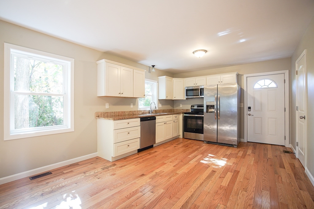 18-20 Healey Street, Unit 20 Springfield, MA 01151 - Photo 4 of 14 a kitchen with granite countertop a refrigerator and wooden floor