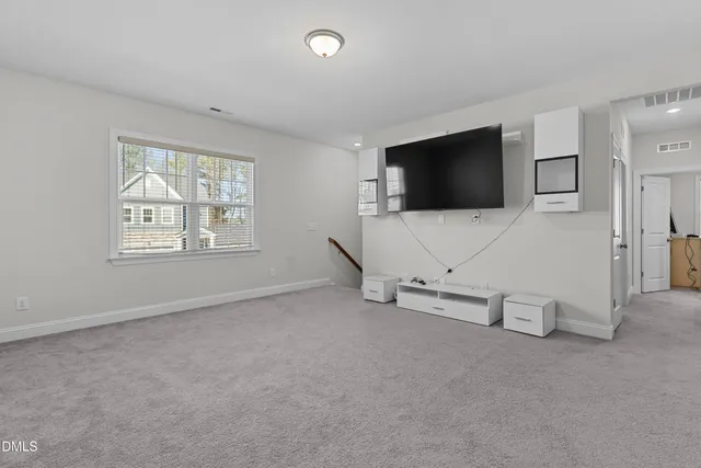 an empty room with windows and television