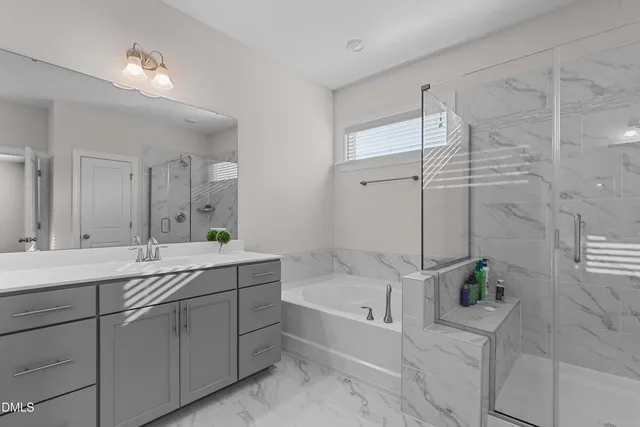 a spacious bathroom with a double vanity sink a large mirror and a bathtub