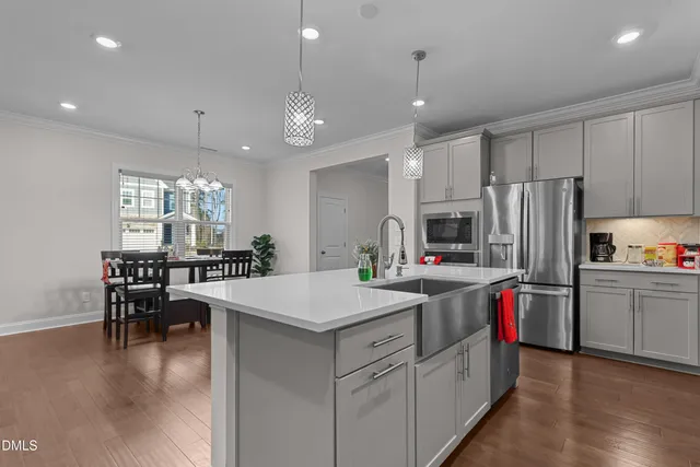 a kitchen that has a lot of cabinets a sink and a refrigerator