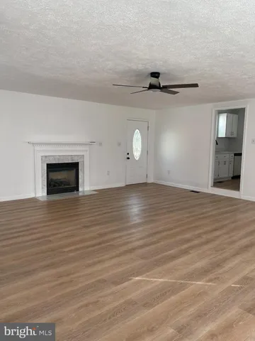 a view of a livingroom with wooden floor and a ceiling fan