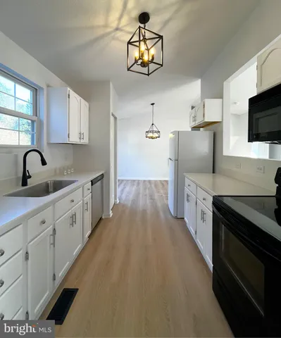 a kitchen with stainless steel appliances a refrigerator a sink a stove a microwave a sink and cabinets