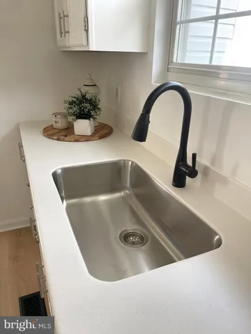 a kitchen with white cabinets and a window