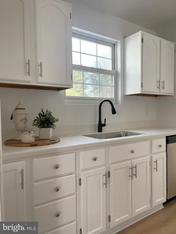 a kitchen with cabinets appliances a sink and a window