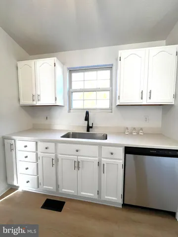a kitchen with white cabinets and refrigerator