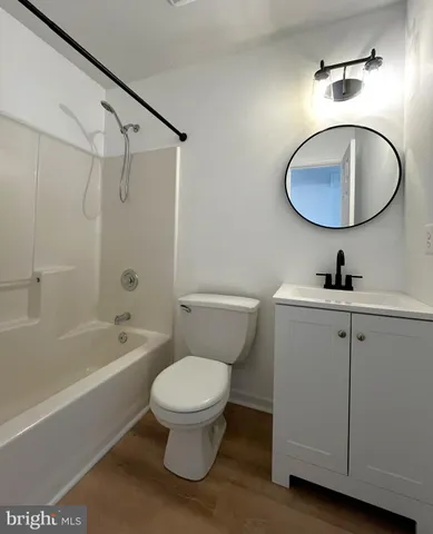 a bathroom with a toilet a sink a mirror and bathtub