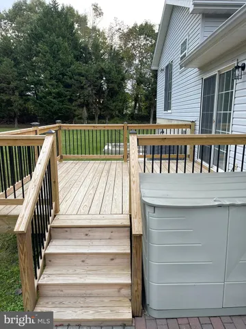 a view of a hallway with wooden floor and chandelier