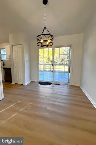 a view of a room with wooden floor exposed radiator and windows