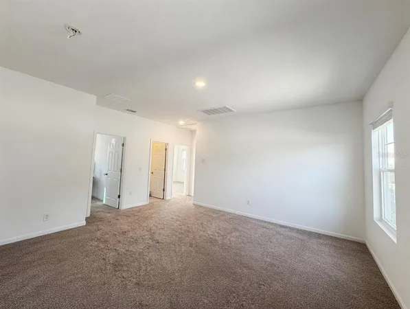 an empty room with windows and closet