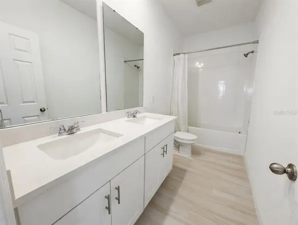 a spacious bathroom with a bathtub shower sink mirror and toilet