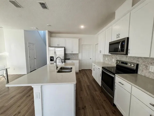 a kitchen with sink a microwave a stove and refrigerator