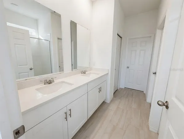 a spacious bathroom with double vanity and mirrors