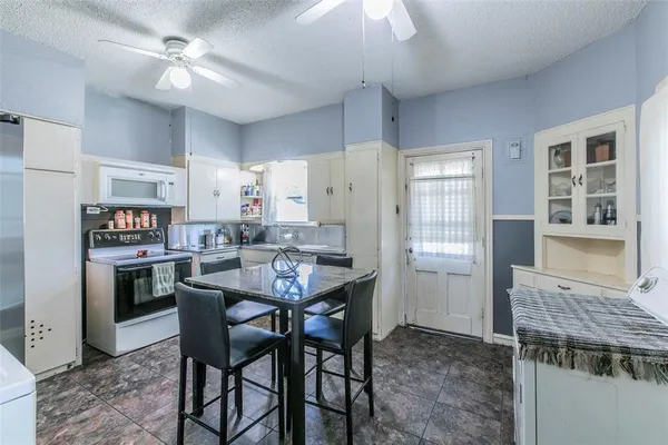 a kitchen with a table chairs refrigerator and cabinets