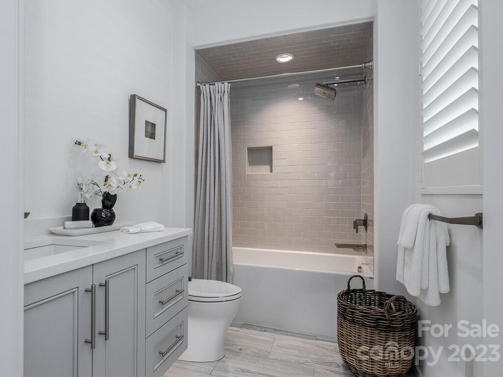 1333 Queens Road, Unit E1 Charlotte, NC 28207 - Photo 16 of 19 a bathroom with a granite countertop sink a toilet and shower