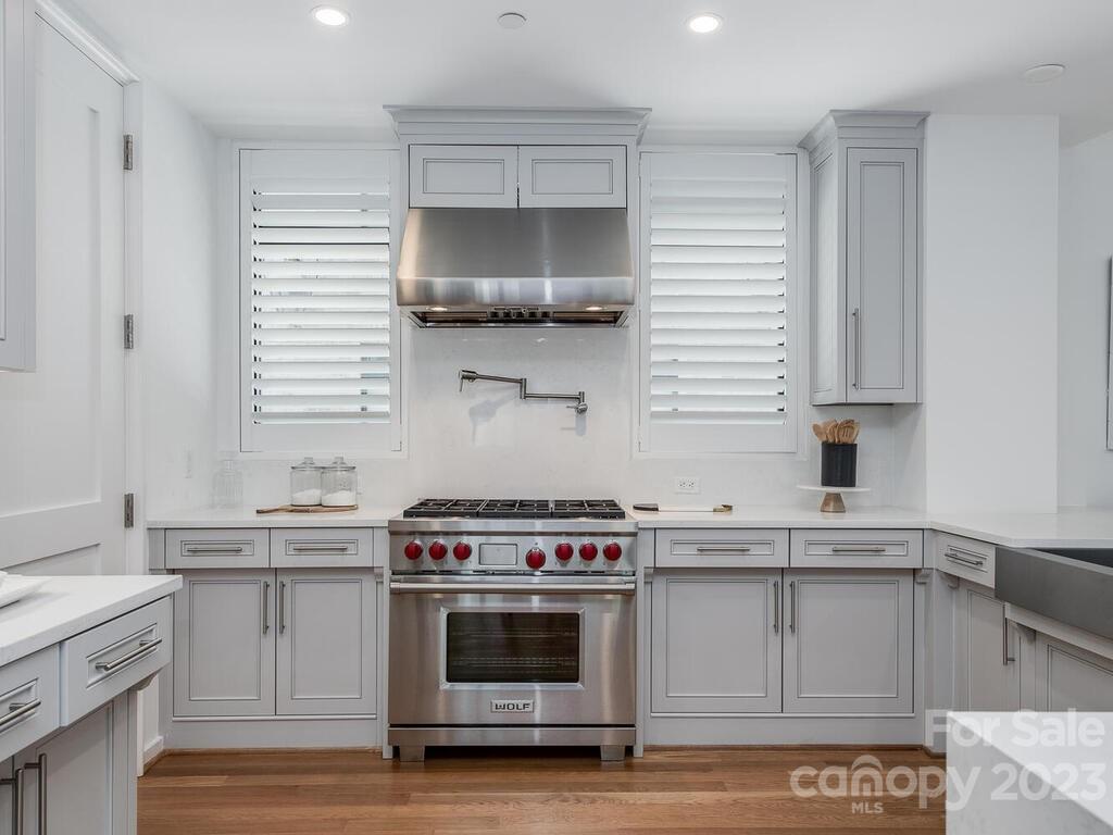 1333 Queens Road, Unit E1 Charlotte, NC 28207 - Photo 7 of 19 a kitchen with a stove a sink and wooden floor