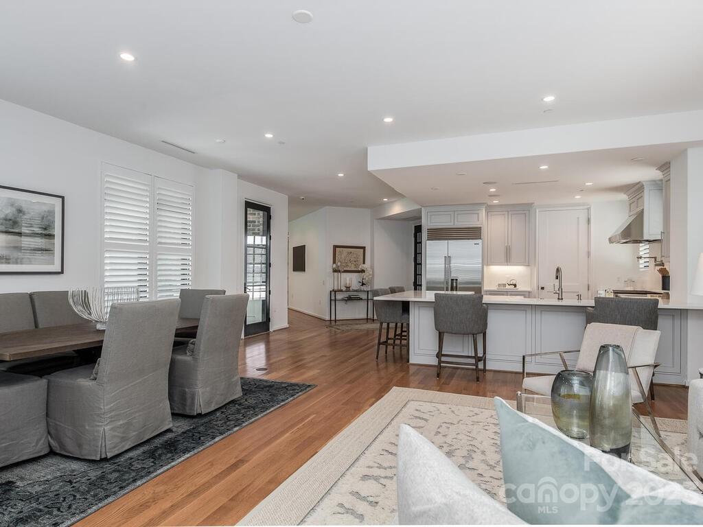 1333 Queens Road, Unit E1 Charlotte, NC 28207 - Photo 10 of 19 a living room with furniture a dining table and kitchen view with wooden floor