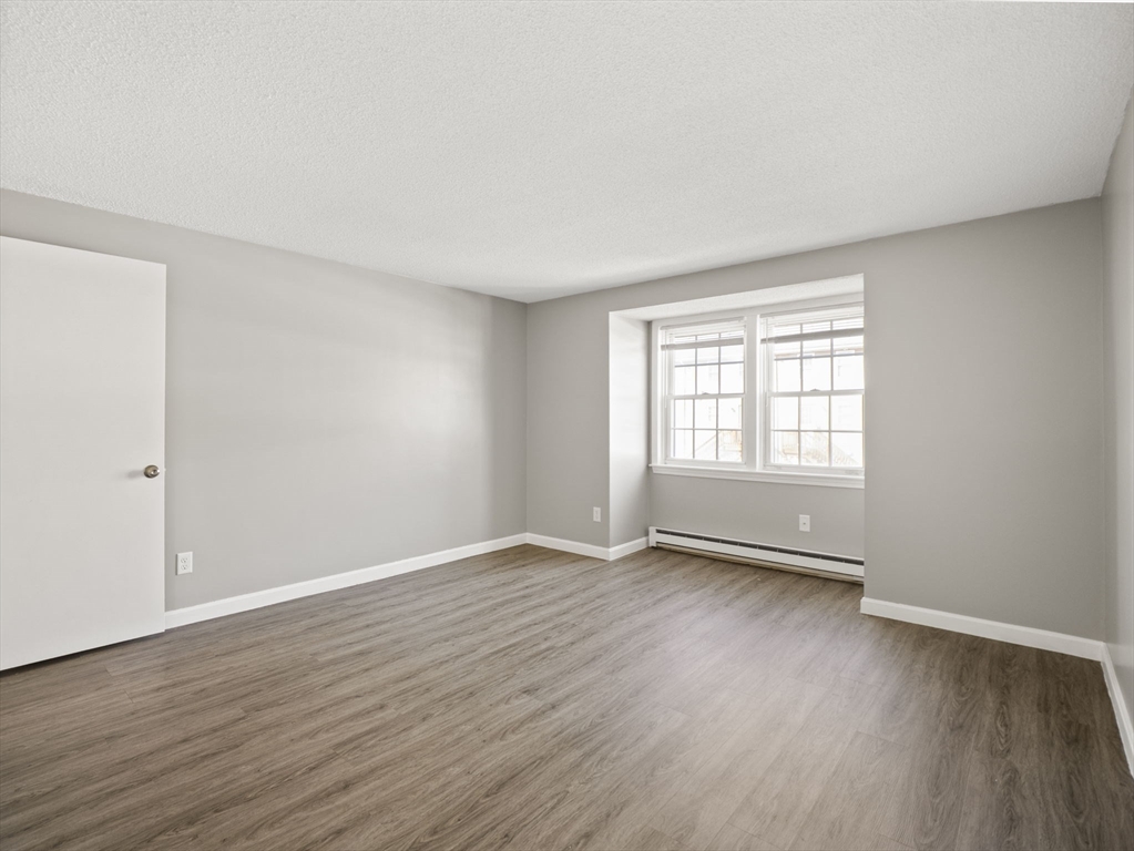 1821 Middlesex Street, Unit 10 Lowell, MA 01851 - Photo 14 of 26 a view of an empty room with wooden floor and a window