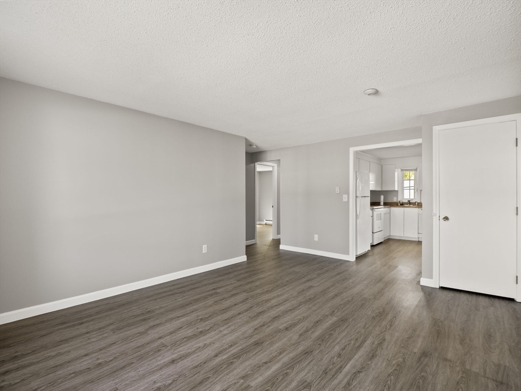 1821 Middlesex Street, Unit 10 Lowell, MA 01851 - Photo 8 of 26 a view of an empty room with wooden floor and a window
