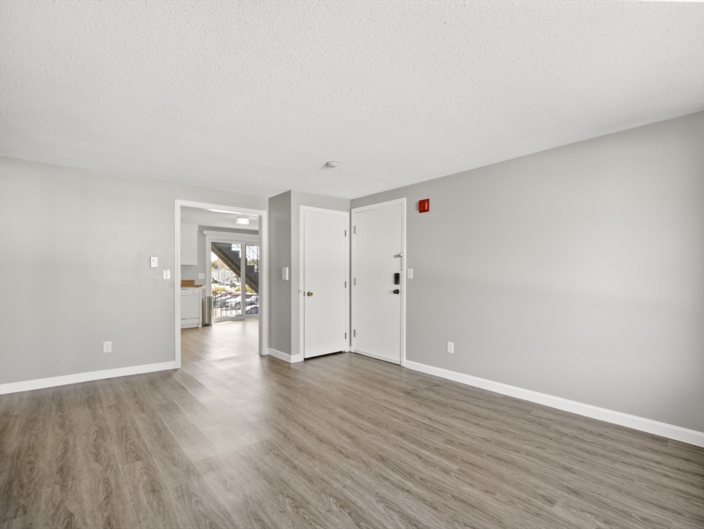 1821 Middlesex Street, Unit 10 Lowell, MA 01851 - Photo 9 of 26 a view of an empty room and wooden floor and a bathroom