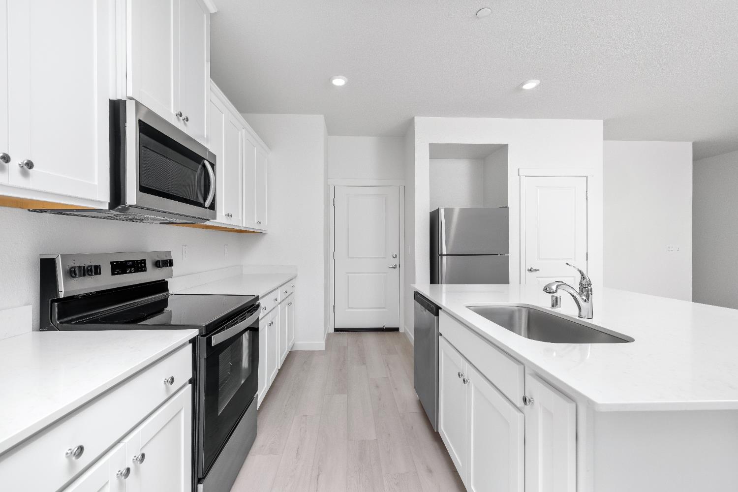 929 South Mylea Court Stockton, CA 95215 - Photo 6 of 8 a kitchen with stainless steel appliances granite countertop a sink dishwasher stove and microwave with wooden floor
