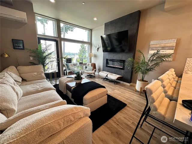 a living room with furniture a flat screen tv and a large window