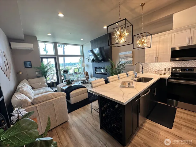 a open kitchen with stainless steel appliances granite countertop a sink stove and wooden floor