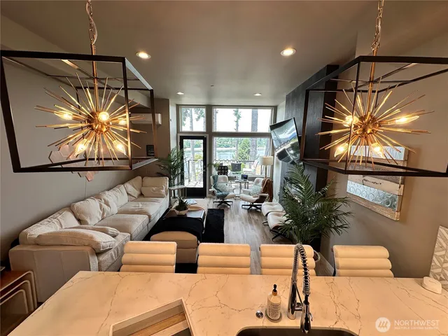 a living room with furniture a chandelier and a large window