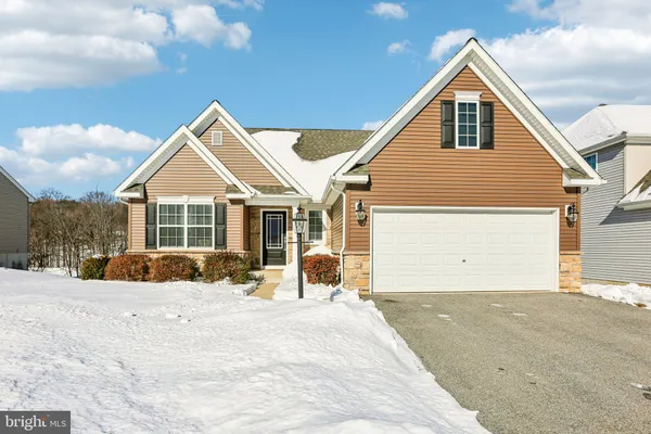 a front view of a house with a yard covered in snow