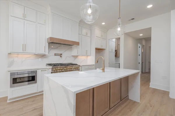 a kitchen with white cabinets and a stove