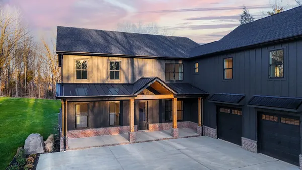 a view of house with backyard and outdoor seating
