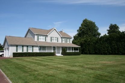 a front view of a house with a yard and trees