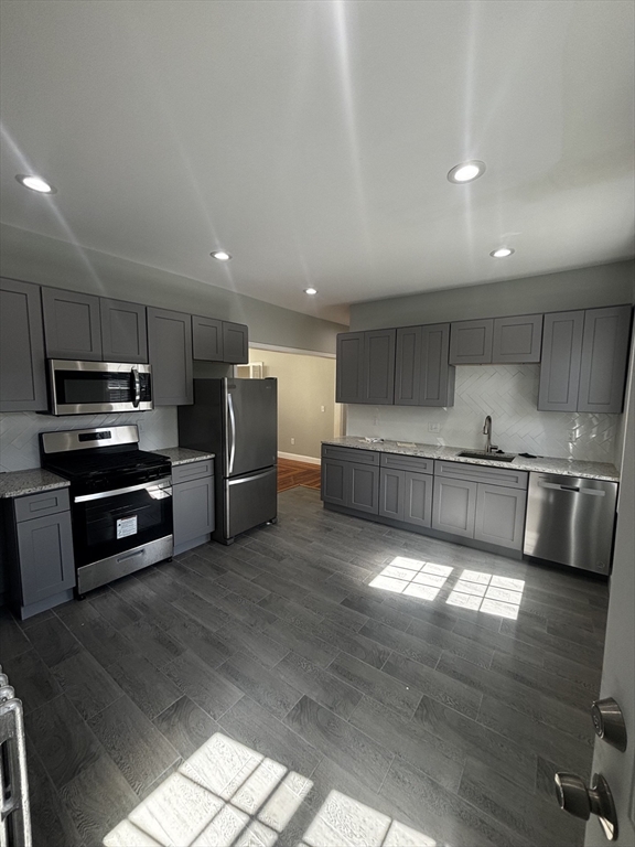 a kitchen with stainless steel appliances kitchen island granite countertop a refrigerator and a stove top oven