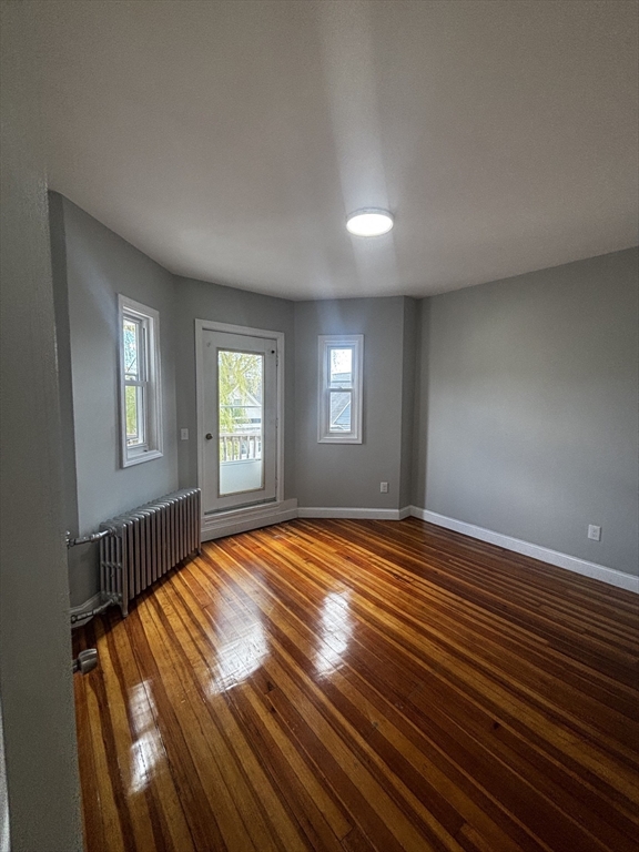 33 Wolcott Street, Unit 3 Boston, MA 02121 - Photo 4 of 8 a view of empty room with window and wooden floor