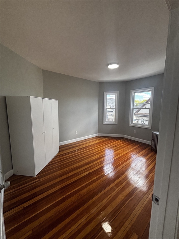 33 Wolcott Street, Unit 3 Boston, MA 02121 - Photo 5 of 8 a view of empty room with window and wooden floor