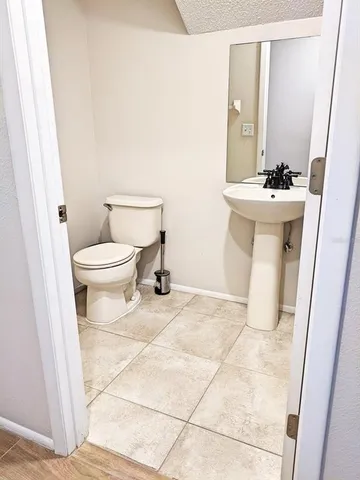a bathroom with a sink a toilet and a mirror