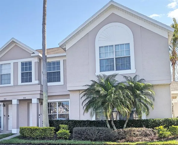 a front view of a house with garage and plants