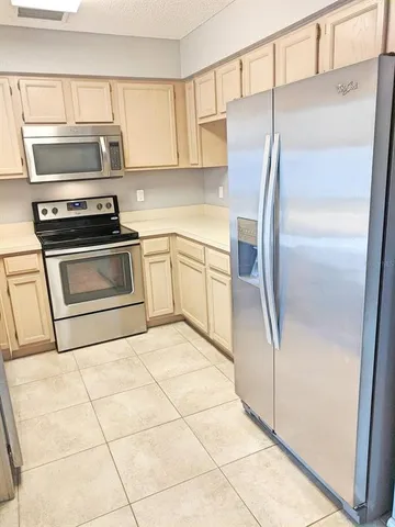 a kitchen with granite countertop a refrigerator and a stove top oven