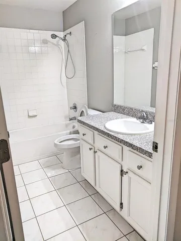 a bathroom with a granite countertop sink a toilet and a mirror
