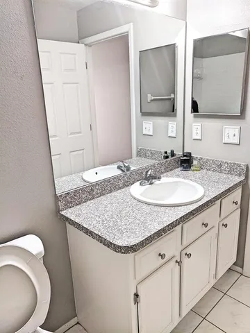 a bathroom with a granite countertop sink and a mirror