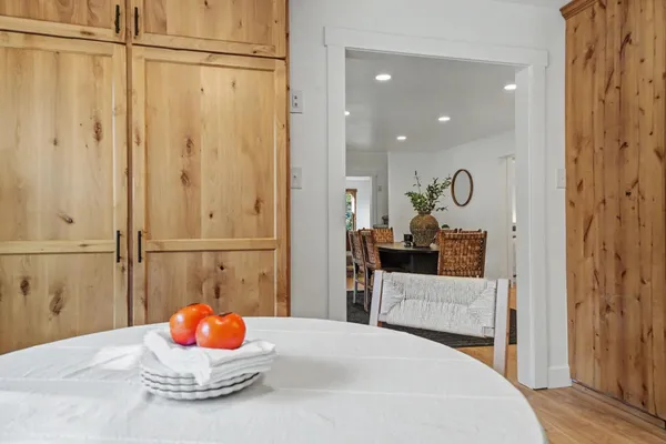 a kitchen with stainless steel appliances kitchen island granite countertop a refrigerator a stove a sink dishwasher and white cabinets with wooden floor