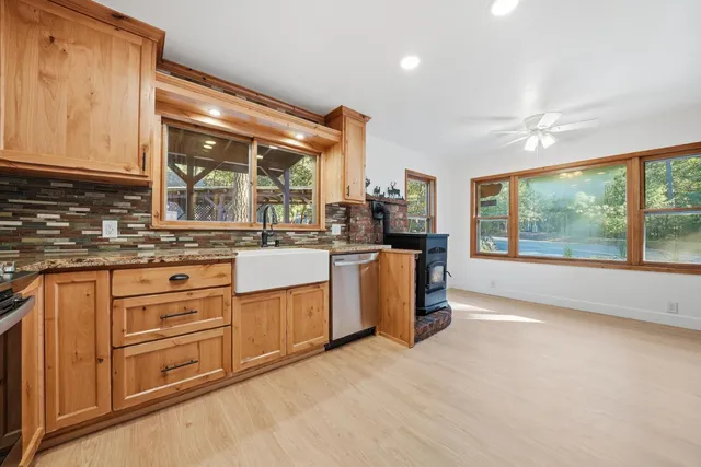 a kitchen with stainless steel appliances granite countertop a stove a sink and a microwave