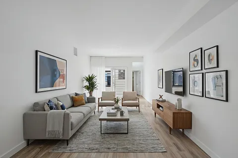 a living room with furniture and wooden floor