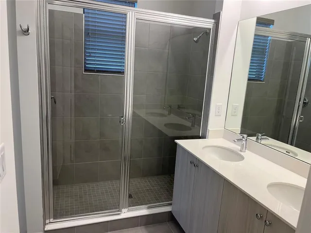 a bathroom with a double vanity sink and mirror